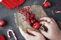 Female hands create a Christmas decoration, wreath, bouquet, on a dark concrete table. Christmas decorations for the home.