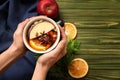 Female hands with cup of tasty mulled wine on wooden background Royalty Free Stock Photo