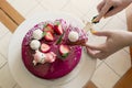 Female hands cut an appetizing pink mousse cake, top view