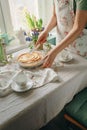 Female hands cut an apple sweet pie, in light colors. sunny time in spring. Royalty Free Stock Photo