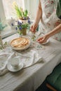 Female hands cut an apple sweet pie, in light colors. sunny time in spring. Royalty Free Stock Photo