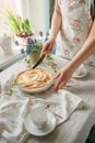 Female hands cut an apple sweet pie, in light colors. sunny time in spring. Royalty Free Stock Photo