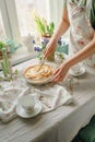 Female hands cut an apple sweet pie, in light colors. sunny time in spring. Royalty Free Stock Photo