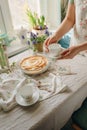 Female hands cut an apple sweet pie, in light colors. sunny time in spring. Royalty Free Stock Photo