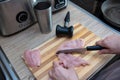 Female hands cut chicken fillet on wooden board with a knife Royalty Free Stock Photo