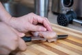 Female hands cut chicken fillet on wooden board with a knife Royalty Free Stock Photo