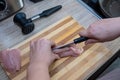 Female hands cut chicken fillet on wooden board with a knife Royalty Free Stock Photo