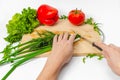 Female hands cut green onions with knife on wooden board. Colorful vegetables. White background Royalty Free Stock Photo