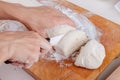 Female hands cut with a knife a kneaded dough on a wooden board. Natural home cooking Royalty Free Stock Photo