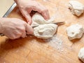 Female hands cut with a knife a kneaded dough on a wooden table Royalty Free Stock Photo