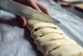 Female hands cut the rolled puff pastry into equal pieces. In the middle, there is a pepper, ham, garlic sauce, and corn. Royalty Free Stock Photo