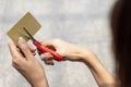 Female hands cutting credit card with scissors.