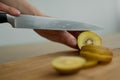 Female hands is cutting a fresh ripe golden kiwi fruit on a cut wooden board. Exotic fruits, healthy eating concept Royalty Free Stock Photo