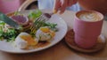 Female hands is cutting a poached egg. Yellow liquid slow motion. Royalty Free Stock Photo