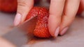 female hands cutting strawberry macro