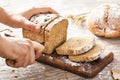 Female hands cutting whole wheat bread