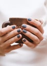 Female hands with dark blue manicure.