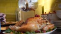 Female Hands Decorate Roasted Whole Chicken on Plate For Family Dinner Royalty Free Stock Photo