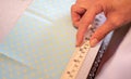 Female hands of designer at work with fabric close-up. Tailor measuring necessary amount of material for sewing cloth Royalty Free Stock Photo