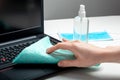Female hands disinfecting laptop keyboard using Disinfectant spray, Alcohol sanitizer, wet disinfectant wipes. Woman cleaning