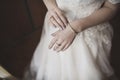 The female hands of the fair-skinned bride lie on the white wedding dress Royalty Free Stock Photo