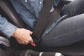 Female hands fasten the seat belt in the car.