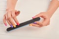 Female hands filing nails with nail file. Royalty Free Stock Photo