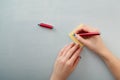 Female hands with fir-tree forest manicure holding red pen over yellow paper stickers. Christmas or winter nail art. Hands care Royalty Free Stock Photo