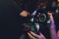 Female hands fold folding stereo headphones on a club background.