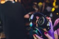 Female hands fold folding stereo headphones on a club background.