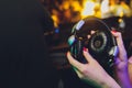 Female hands fold folding stereo headphones on a club background.