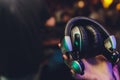 Female hands fold folding stereo headphones on a club background.