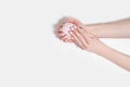 Female hands with a gentle manicure on a white wooden background. Marshmallow in the hands