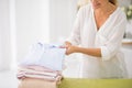 Female hands gently folding ironed clothes
