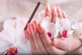 Young Beautiful Woman with Gently Pink Nails Holding White Orchid Flower