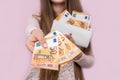 Female hands giving euro banknotes on pink background Royalty Free Stock Photo