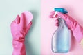 Female hands in glove holds window spray and sponge on pink and blue background, top view, spring cleaning concept Royalty Free Stock Photo