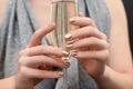 Female hands with gold nail design. Gold glitter nail polish manicure. Woman hold champagne glass Royalty Free Stock Photo