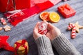 Female hands in gray knitted sweater holding glass snowball on C