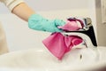 Female hands with green rubber protective gloves cleaning tap Royalty Free Stock Photo