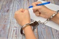 Woman in handcuffs. To sign a guilty verdict. The conviction and prison sentence. Royalty Free Stock Photo