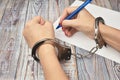 Woman in handcuffs. To sign a guilty verdict. The conviction and prison sentence. Royalty Free Stock Photo