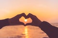 Female hands heart shape on sunset sky at tropical beach abstract background. Copy space of happy love travel and freedom in Royalty Free Stock Photo