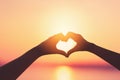 Female hands heart shape on sunset sky at tropical beach abstract background. Copy space of happy love travel and freedom in Royalty Free Stock Photo