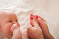 Female hands hold the baby`s legs and arms, newborn care concept, abdominal colic massage, teething. Massage for a newborn Royalty Free Stock Photo