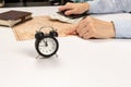 Female hands hold a black leather wallet with money and show the resting place on the world map. on a white wooden table brown dia Royalty Free Stock Photo