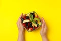 Female hands hold bowl of fruit salad on background Royalty Free Stock Photo