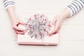 Female hands hold box wrapped in pink paper with bow Royalty Free Stock Photo