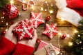 Female hands hold the Christmas gingerbread stars cookies over wooden background with fir branches, decorations, lights garland, Royalty Free Stock Photo