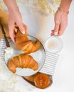 Female hands hold a cup of coffee and take a croissant, continental breakfast on a table, orange jam, butter, croissant Royalty Free Stock Photo